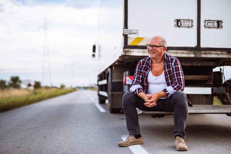 Chauffeur bij zijn vrachtwagen langs de weg